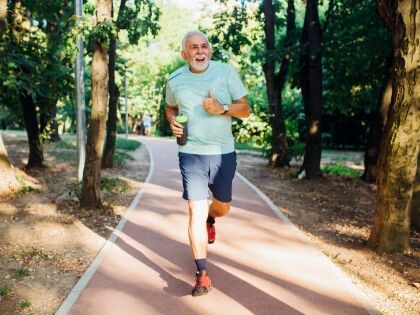 An older man jogging on a park path